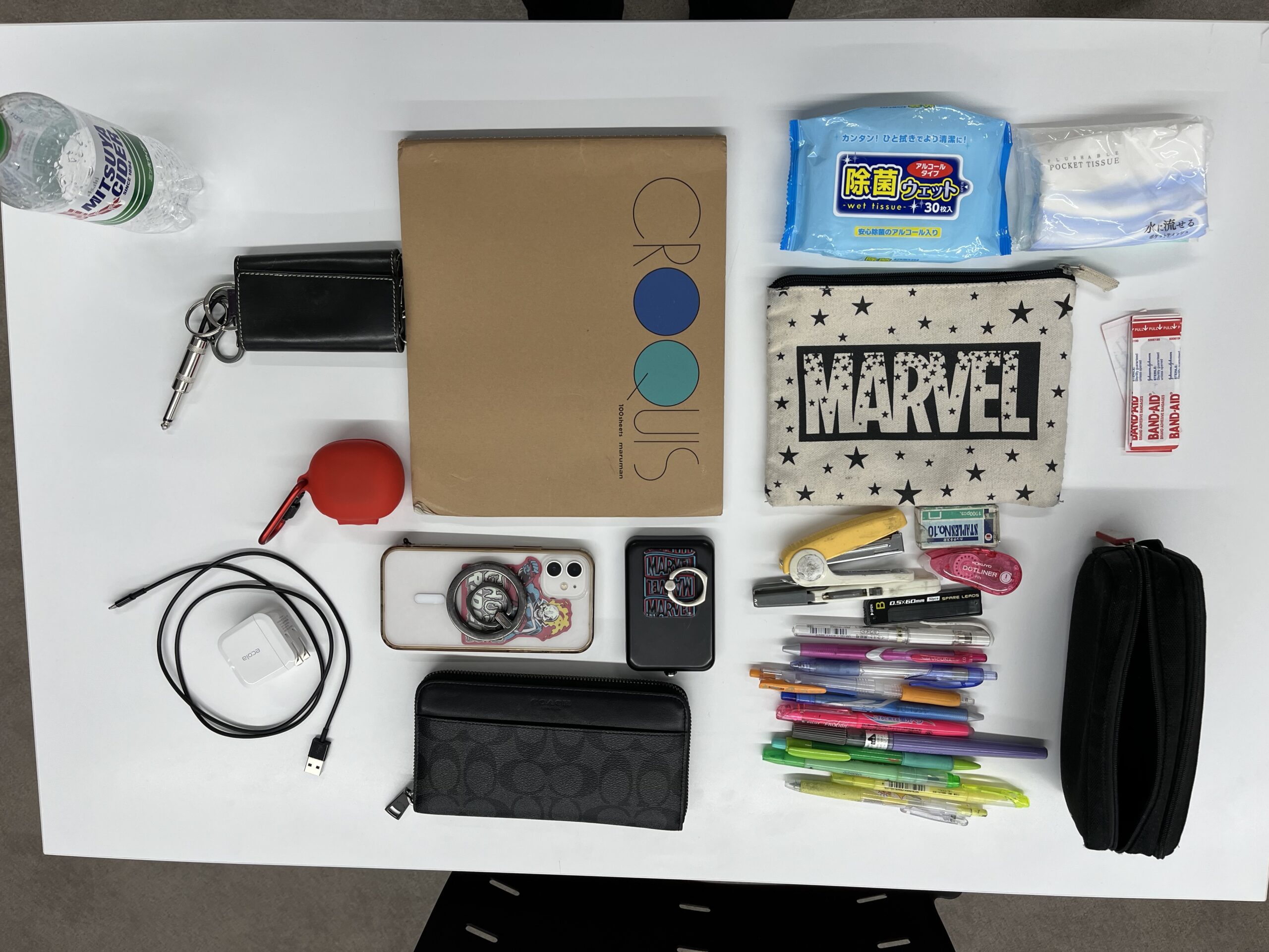 この生徒のバッグの中身は、クロッキー帳、蛍光ペン、ばんそこう、ウエットティッシュ、ワイヤレスイヤホン、スマホ、ジュース、ティッシュ、カギ、筆箱など。