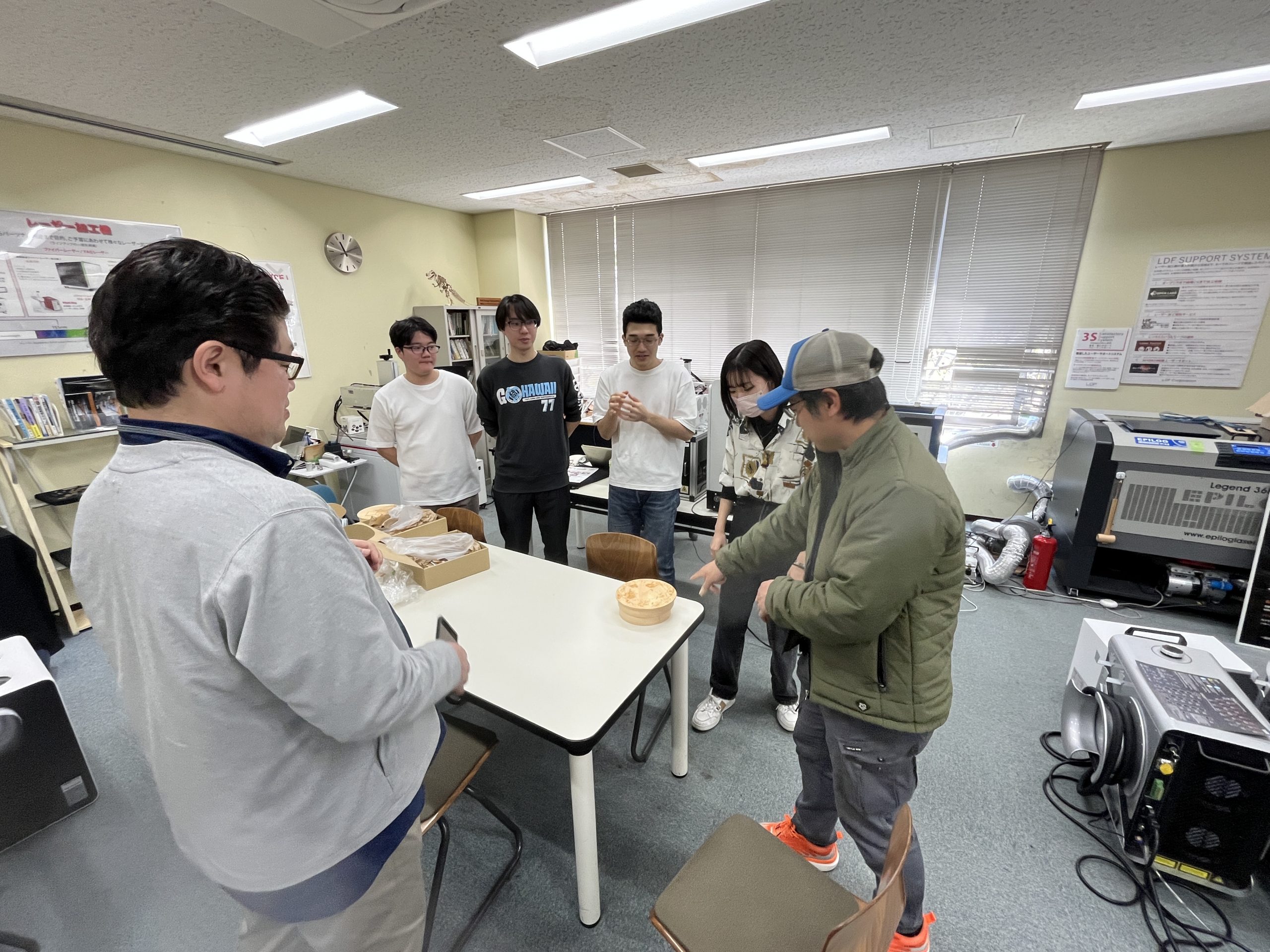 ▲三澤さんと宮木准教授、デザイン学科の学生たち。